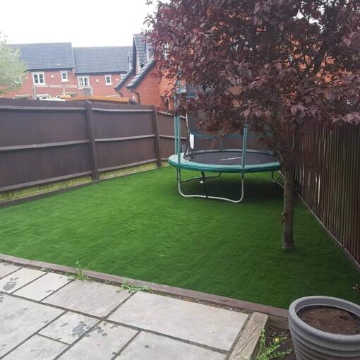 This is a photo of a trampoline on fake grass in Leicester. Leicester artificial grass services installed this
